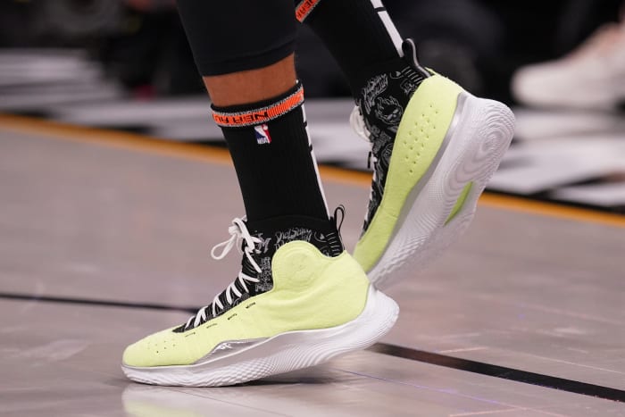 View of yellow and white Curry shoes.